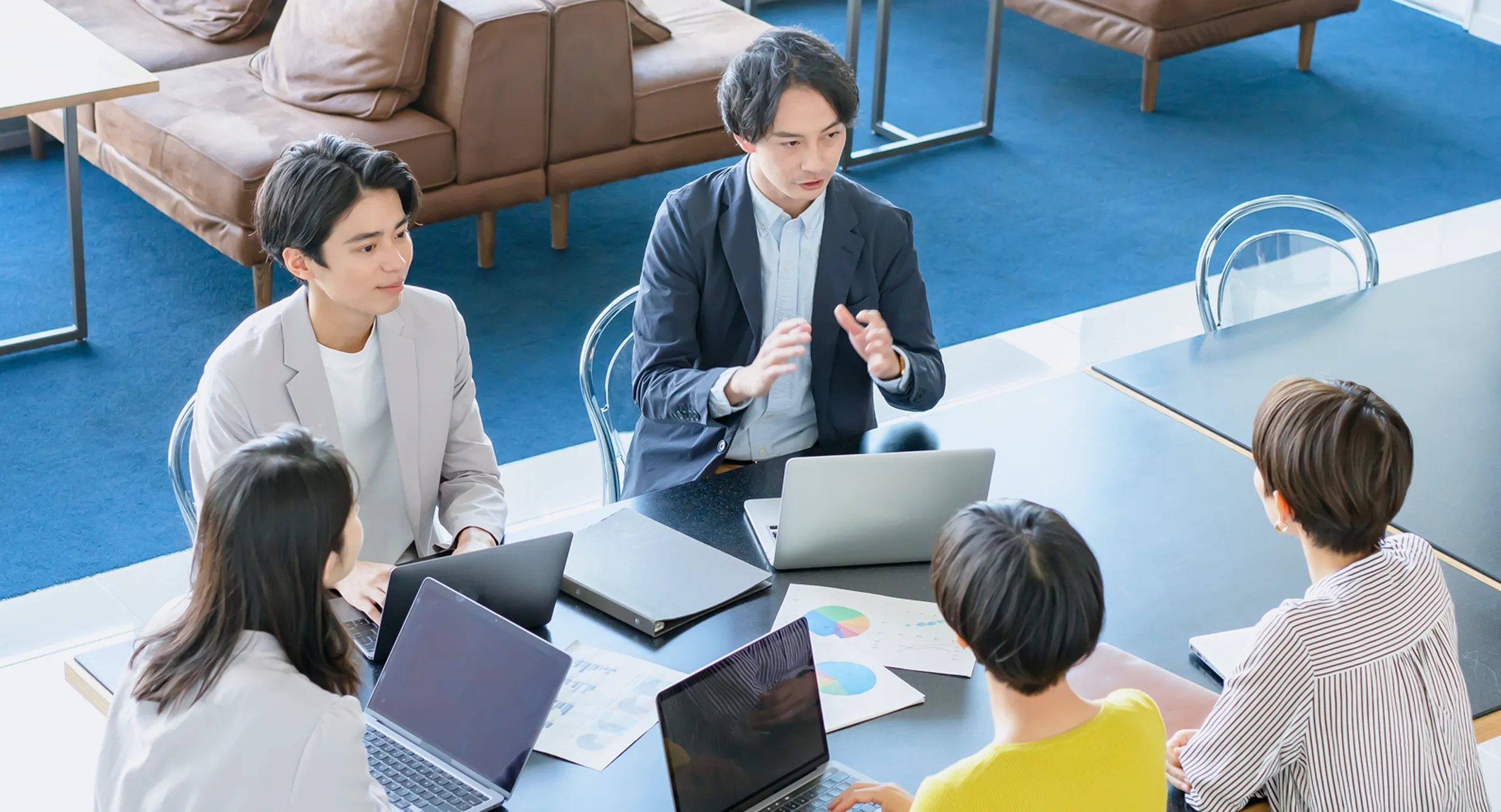ミーティングルームで打ち合わせをする社員たち