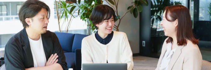 オフィスで談笑する社員3人