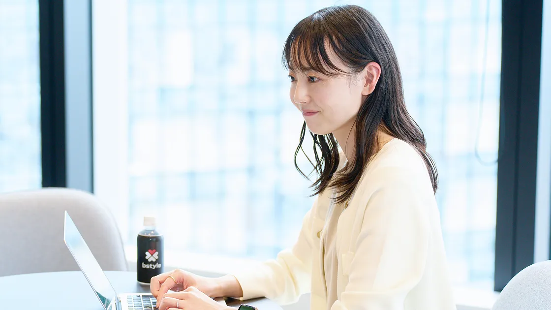 ノートパソコンに向かって作業するS.Fさん